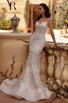 a woman in a wedding dress standing on a balcony