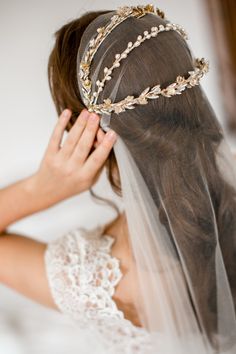 a woman wearing a veil with a tiara on top of her head and hair comb in front of her face