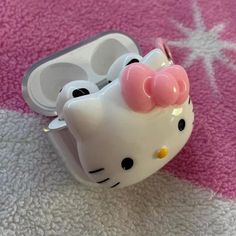 a hello kitty earbud holder on a pink carpet