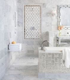 a white bathroom with marble walls and floors