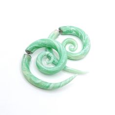 two green spiral shaped beads sitting on top of each other