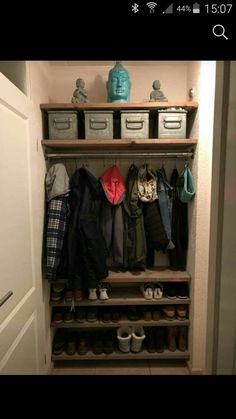 an open closet with shoes and coats on the shelves