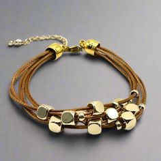 Get ready to elevate your wrist game with this multi-strand leather bracelet. Featuring gold-plated floating beads and a lobster clasp closure, this timeless piece is the perfect way to add a touch of sophistication to any outfit. Length: 6.5" + 1.5" extender chain Lobster clasp closure - for a secure fit 6 strands of brown leather - for the perfect boho vibe 18K PVD Gold plated stainless steel - long lasting plating and hypoallergenic Handmade in China - to bring you the best possible price Thi Adjustable Gold Leather Bracelet Chic Style, Adjustable Gold Leather Chic Bracelet, Gold Leather Bracelet As Fashion Accessory, Adjustable Gold Leather Jewelry, Adjustable Multi-strand Modern Jewelry, Nickel-free Multi-strand Gold Jewelry, Gold Multi-strand Nickel-free Jewelry, Gold Nickel-free Multi-strand Jewelry, Chic Leather Bracelet Jewelry