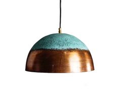 a copper and blue pendant light hanging from a ceiling