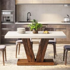 a white table with chairs around it in the middle of a living room and kitchen area