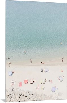 an aerial view of people on the beach with umbrellas and chairs in the sand