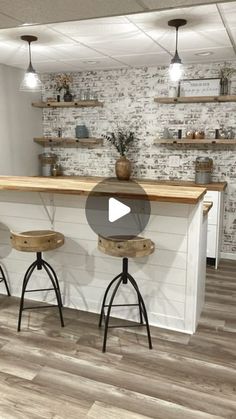 a kitchen with two stools in front of an island