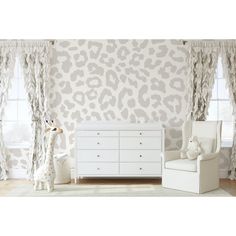 a baby's room with white furniture and leopard print wallpaper on the walls