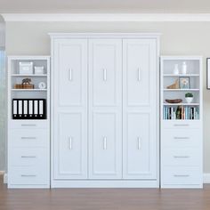 an empty room with white cabinets and bookshelves