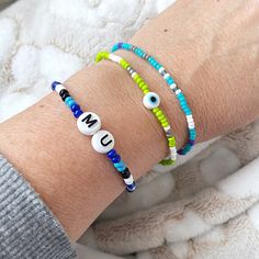 two bracelets with evil eyes and the word un on them are sitting on a person's arm