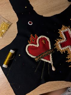 a black shirt with gold sequins on it and some scissors next to it