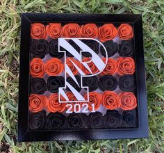 a black box with orange and white rolled roses in the shape of letters r and z