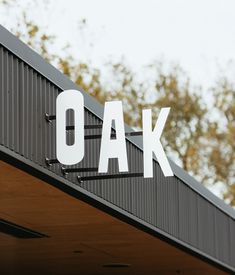 the word oak is painted on top of a metal structure with trees in the background