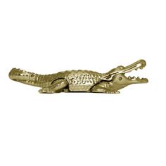 a gold alligator figurine on a white background