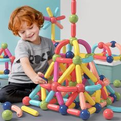 a young boy playing with an assortment of toys