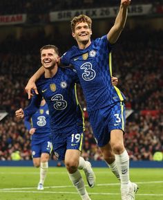 two soccer players are celebrating on the field