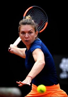 a woman swinging a tennis racquet at a ball with a racket in her hand