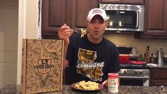 a man holding a plate of food in front of a box of macaroni and cheese