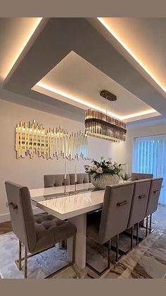 a dining room table with chairs and a chandelier hanging from it's ceiling