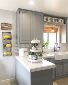 a kitchen with gray cabinets and white counter tops