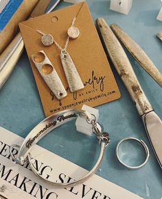 a pair of scissors and some silverware are on a table next to a book