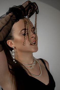 a woman with pearls on her head and black dress