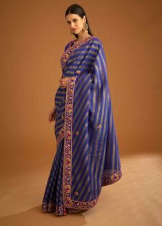 Editor's Note The gota and thread embroidered chanderi gold jacquard sari is a beautiful and luxurious ethnic attire. The sari is embellished with intricate embroidery work that adds a rich texture to the gold jacquard fabric. It comes with a matching embroidered brocade blouse and border, which enhances the overall look of the attire. Color: Blue violet Fabric: Silk brocade & chanderi gold jacquard Embroidery details: Gota & thread embroidery Components: Sari & blouse Sari length: 6 meters, sar Violet Fabric, Blouse Sari, Blouse Yoke, Brocade Blouse, Personal Shopping Service, Brocade Blouses, Casual Tunics, Sari Blouse, Silk Brocade