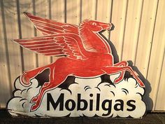 a sign that says mobligas on the front and side of it with a bird flying above it