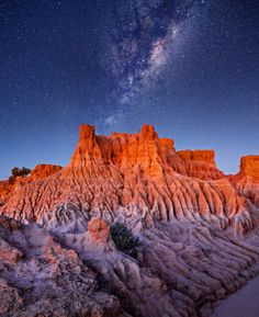 the stars shine brightly in the night sky above some rocky mountains and desert formations with snow on them