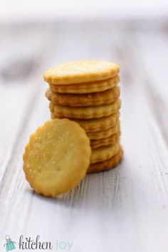 a stack of crackers sitting on top of a wooden table next to a plate of cookies