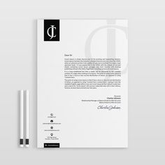 a letterhead and business card on top of a white paper with a pen next to it