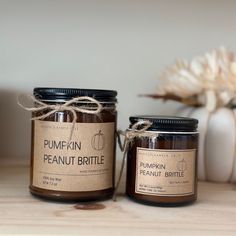 two jars of pumpkin and peanut butter sitting on a table