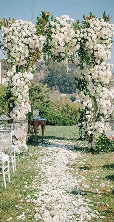 an outdoor ceremony with white flowers and chairs