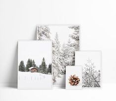 three cards with pine cones on them in front of snow covered trees and a cabin