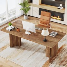 a wooden table with a computer on top of it next to a lamp and potted plant