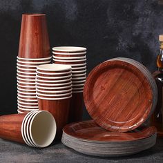 a stack of wooden plates sitting next to each other on top of a black table