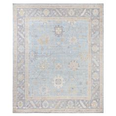 a light blue rug with an ornate design on the front and back side, in various colors