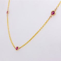 Metal Quality: 14K Yellow GoldPendant Style: By the YardGemstone: RubyGemstone Number: 7Gemstone Shape: RoundGemstone Total Weight: .50 caratsGemstone Color: Deep Red/PinkDiameter of Stones in Bezel: 4.80 millimetersChain Type: CableChain Length: 18 inchesClasp: LobsterChain Diameter: 1 millimeter Yellow Gold Necklaces With Accent Stones For Anniversary, Anniversary Yellow Gold Necklaces With Accent Stones, 14k Gold Necklace With Accent Stones, Yellow Gold Birthstone Necklace With Gemstone Accents For Anniversary, Ruby Gemstone Birthstone Necklace For Anniversary, Pink Gold Gemstone Necklace For Anniversary, Dainty Yellow Gold Gemstones, Elegant Round Birthstone Necklace, Pink Gold Jewelry With Bezel Setting For Formal Occasions