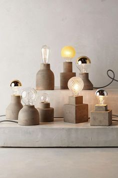 an assortment of light bulbs and lamps on a table