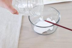 someone is pouring milk into a glass bowl