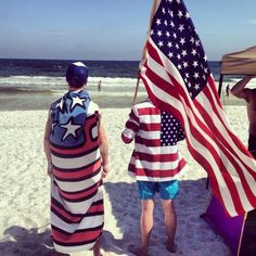 two men with american flags on the beach