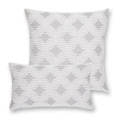 two grey and white pillows sitting next to each other