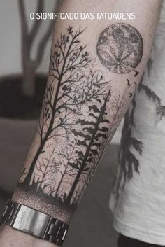 a man's arm with trees and moon tattoo on the left side of his arm