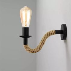 a light that is on the side of a wall with a rope attached to it