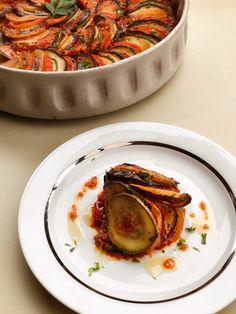 a plate with some food on it next to a pan filled with other food items