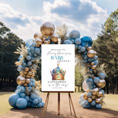 a welcome sign with balloons in the shape of a crown is displayed on an easel