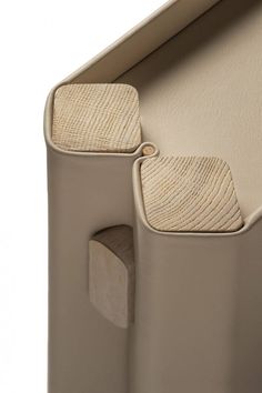 the back end of a beige chair with two wooden seats and an open door on one side