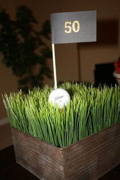 a golf ball sitting on top of green grass in front of a sign that reads 50