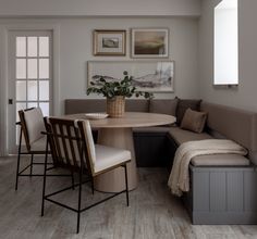 a corner table with four chairs and a bench in front of the door to another room