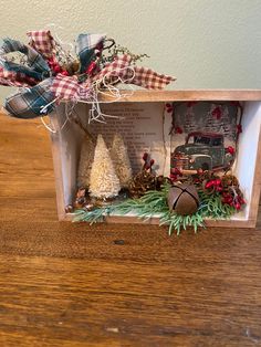 a wooden box filled with christmas decorations on top of a table